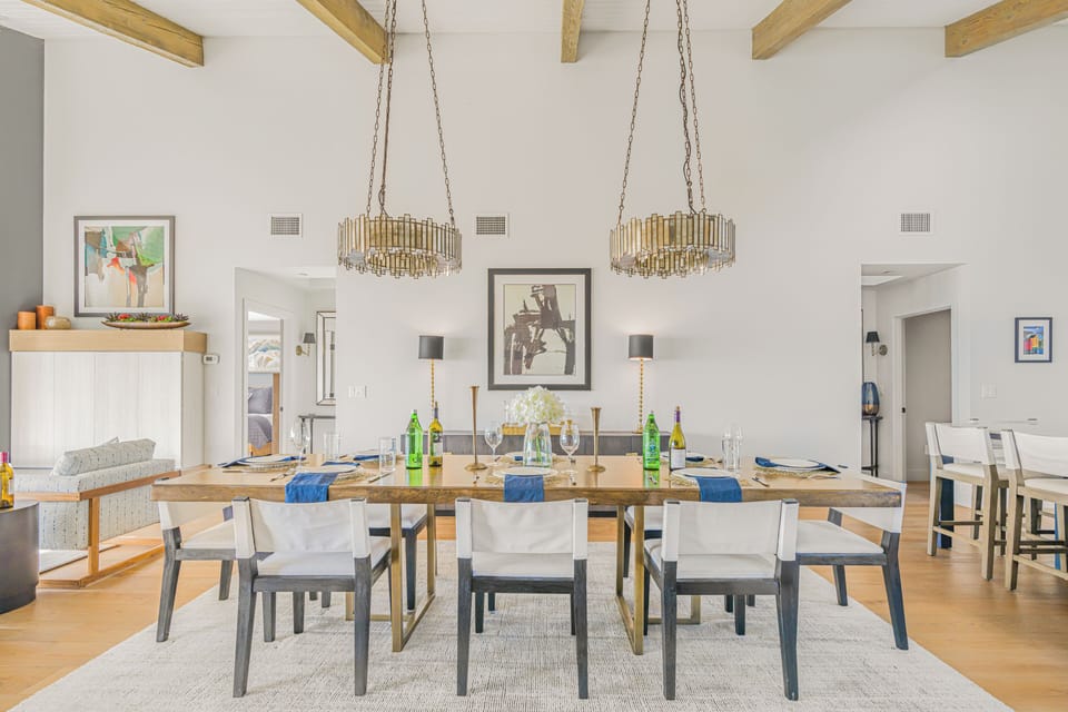 A straight-on shot of the dining room table and matching chandeliers.
