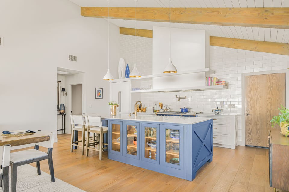 A view of the kitchen island featuring glass-front cabinetry and barstool seating.