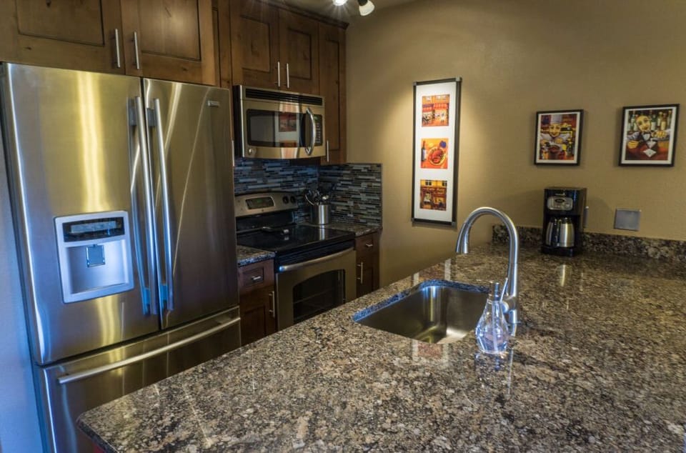 Prepare meals in the sleek modern kitchen with stainless steel appliances, granite countertops, and a spacious layout.