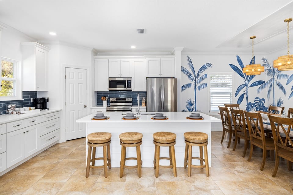Fully equipped chef’s kitchen with island seating and adjacent dining area, offering plenty of room for shared meals and memorable gatherings.