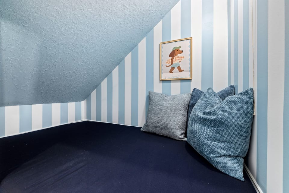 Cozy little hideaway under the stairs designed just for kids — the perfect reading nook or quiet play space for younger guests.