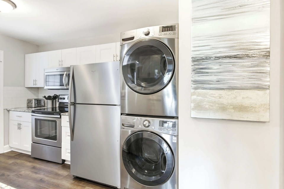 Full-size stacked stainless washer and dryer tucked right off the kitchen, so beach days stay carefree.