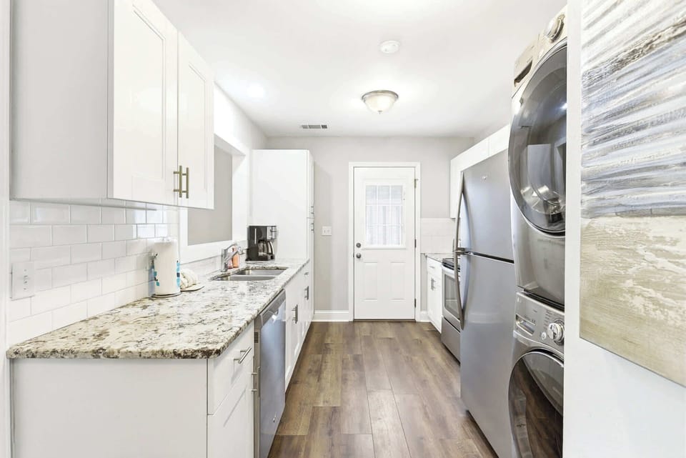 White shaker cabinets, granite countertops, subway tile backsplash, and stainless appliances make this kitchen as functional as it is fresh.