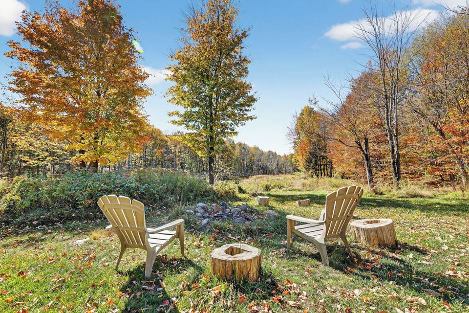 A large backyard area offers lounging chairs and outdoor firepit