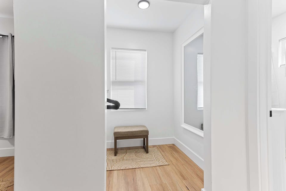 Welcoming bedroom entrance with warm wood floors and bright natural light. A calm and inviting space designed for restful nights and relaxing mornings.