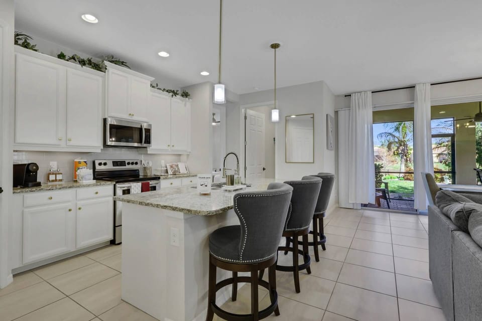 The open kitchen is defined by an eating island with barstool seating for three.
