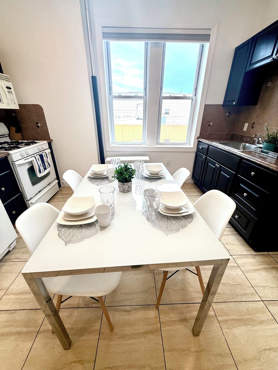 Sunny eat-in kitchen with gas range and modern table for six.