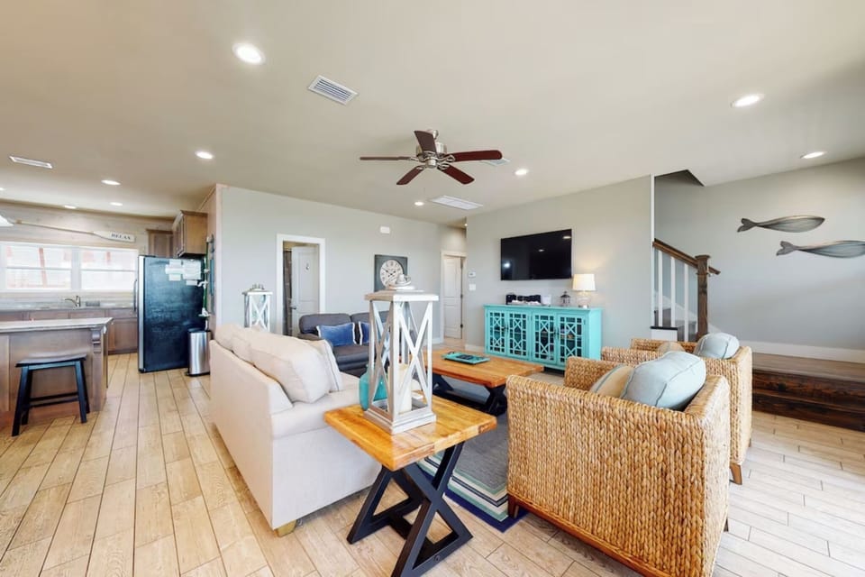 Living room area with plenty of seating and wall mounted Smart TV. Guests must log in to their own streaming services