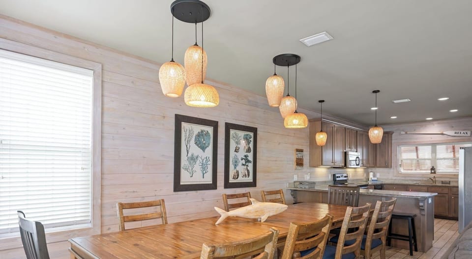 Dining area with a table and chairs set for 8 and additional seating for 4 at the breakfast bar 