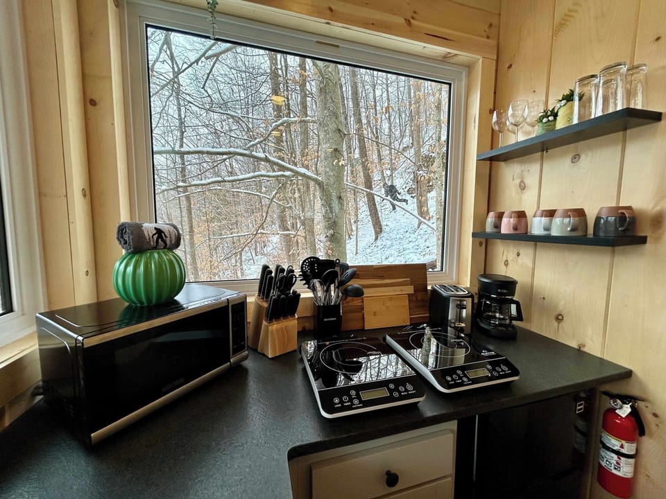 Sunlit countertops and large windows make this kitchen a peaceful place to start your morning.  It includes a mini fridge, microwave, portable induction cooktops, toaster, and a standard drip coffee maker. Please provide your own coffee. 