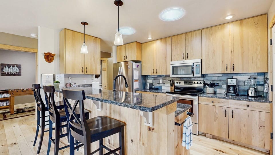Modern kitchen with stainless steel appliances and breakfast bar for 3