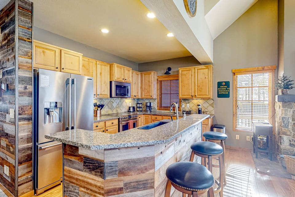 Spacious kitchen island with breakfast bar invites casual meals and lively conversation in Tamarack Chalet's gourmet kitchen.