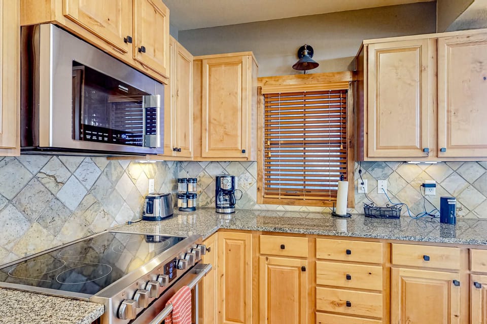 Modern electric stovetop anchors the gourmet kitchen, ready for your culinary creations at Tamarack Chalet.
