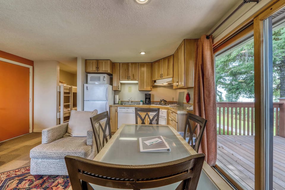 Dining area with kitchen and balcony beyond