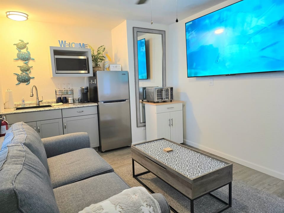 The cute kitchenette has a full sized fridge, microwave, & sink plus we've added a moveable cart and airfry oven.  You'll also have, a Keurig, double burner with pans, dishes, crock pot, & starter coffee pods. 