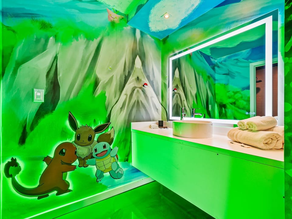 A vibrant bathroom featuring a glowing mirror and playful Pokémon-themed wall art.