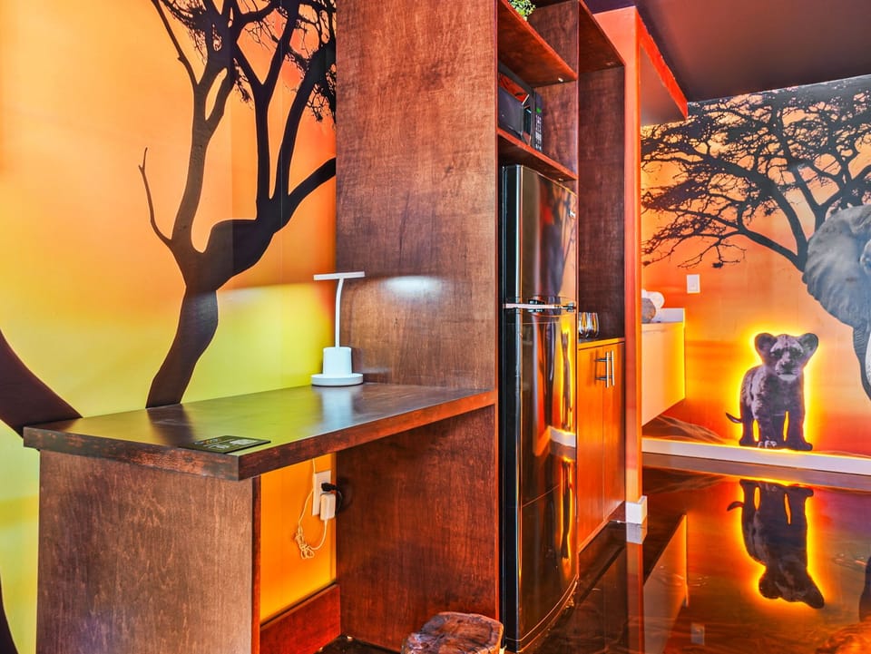 Modern kitchen area with custom wood cabinetry and vibrant wildlife mural walls.