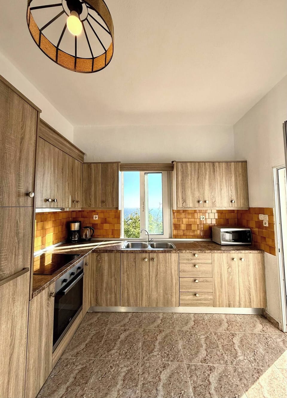 Fully equipped large kitchen with window overlooking the sea.