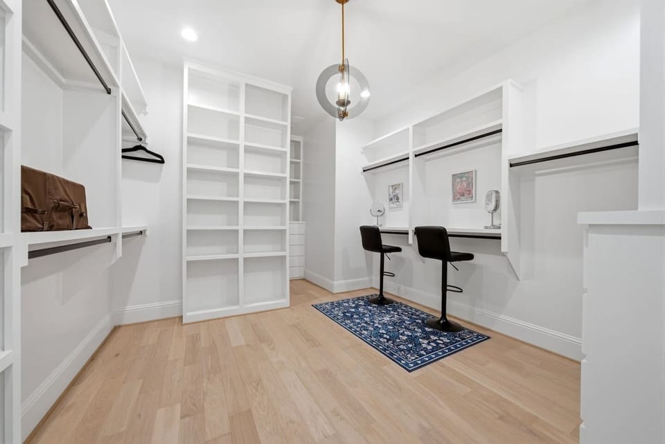Oversized primary walk-in closet with ample storage and two makeup stations, making it easy for multiple guests to get ready for an evening out in Houston.