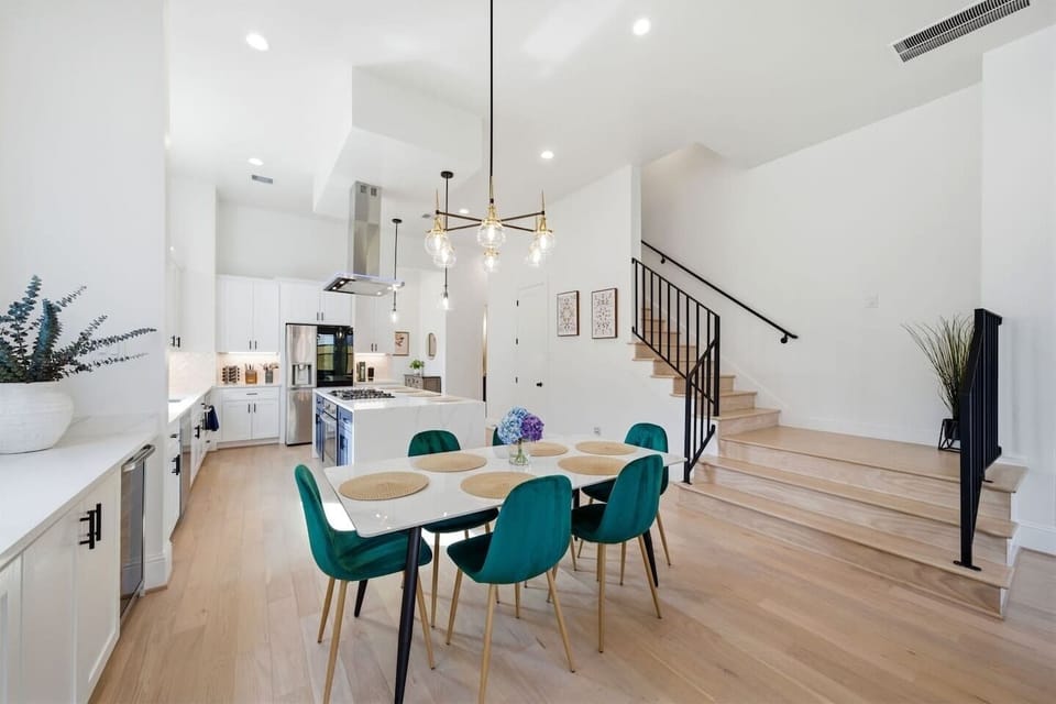 Stylish dining space with seating for six plus four additional seats at the kitchen island, located within the open-concept living area. Perfect for shared meals, morning coffee, or gathering before a night out in Houston.