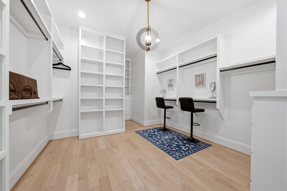 Oversized primary walk-in closet w/storage & two makeup stations.