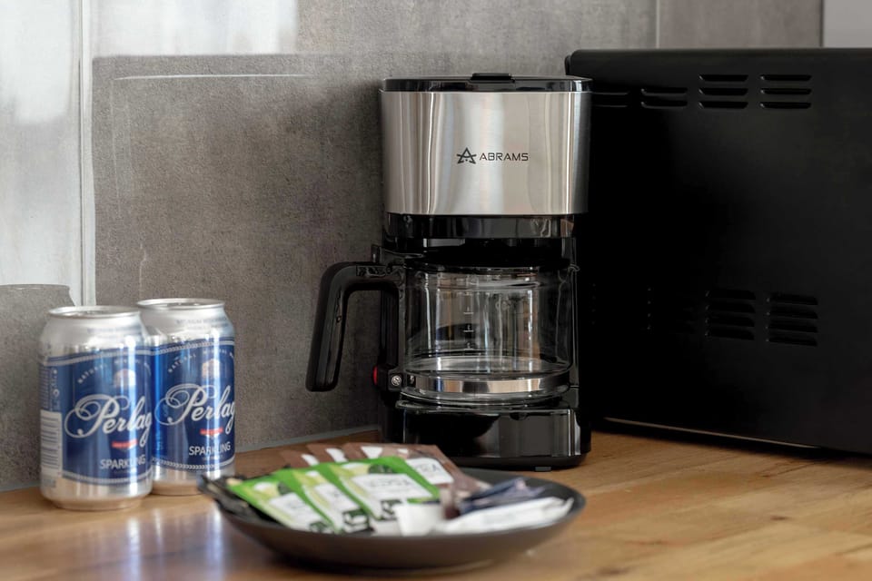 A small coffee station with a coffee machine and cups arranged neatly. The setup suggests convenience for guests.
