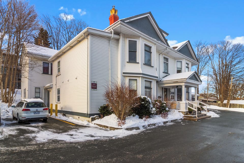 Exterior view of the charming large house with covered porch, winter scenery, and residential neighborhood setting.