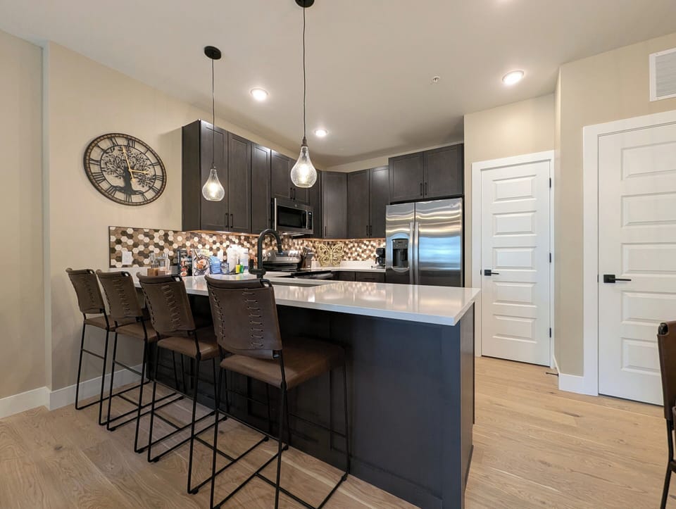 Your stylish kitchen features dark cabinets, quartz counters, and a breakfast bar where you can start mornings with coffee.