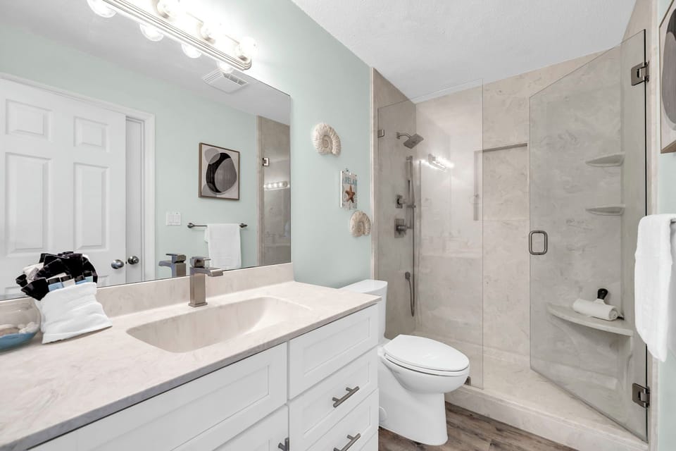 Step into your elegant marble guest bathroom with a spacious glass shower and premium fixtures for ultimate comfort.