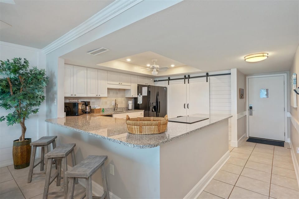Your fully equipped kitchen features granite countertops, modern appliances, and a breakfast bar where you can enjoy morning coffee.