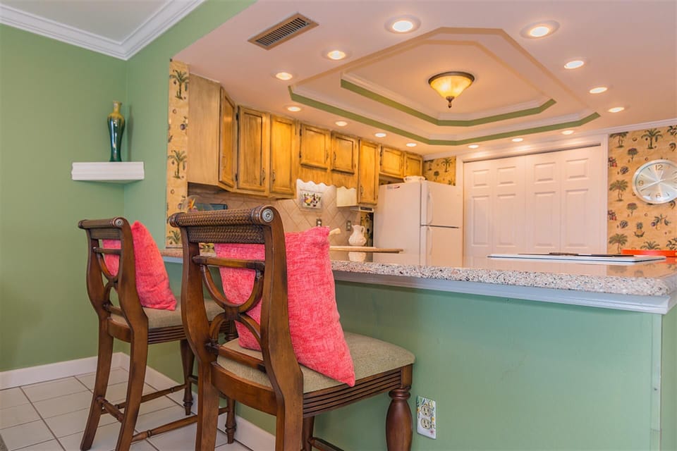 Your bright kitchen invites culinary adventures with granite counters, warm wood cabinets, and tropical charm.