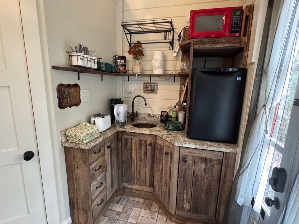 Cozy kitchenette with rustic cabinetry, mini fridge, coffee setup, and everything you need for quick bites and morning coffee.