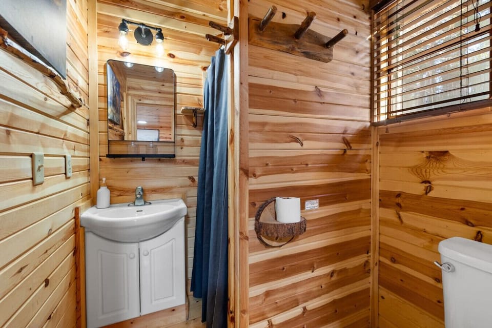 Clean and cozy bathroom with vanity sink, mirror, and shower for a comfortable stay.