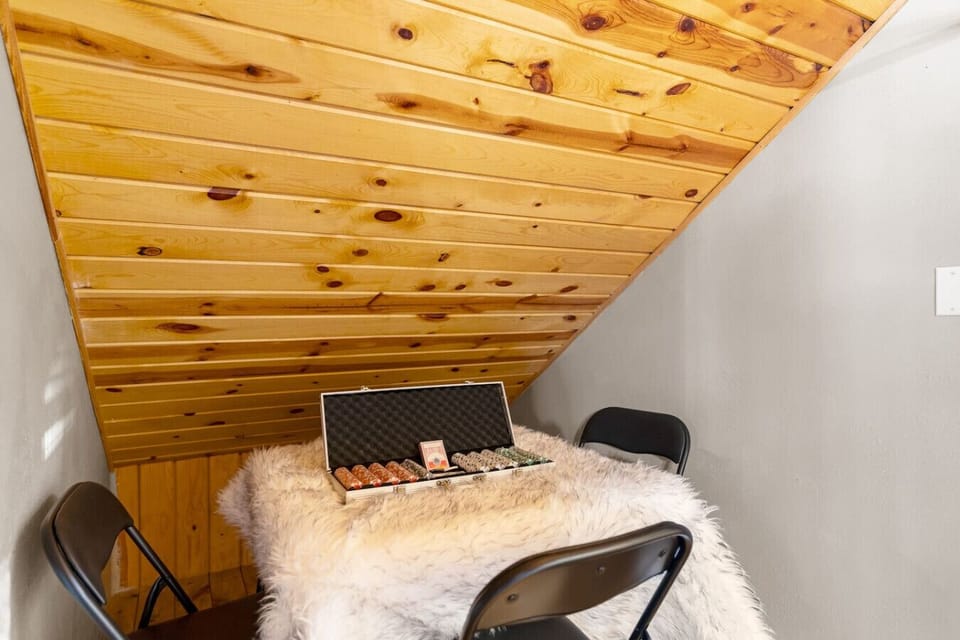 Cozy nook ideal for cards, puzzles, or quiet games under the sloped wood ceiling.