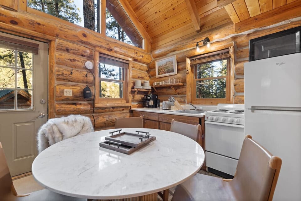 Cook and dine in a light-filled cabin kitchen while enjoying peaceful pine views outside.