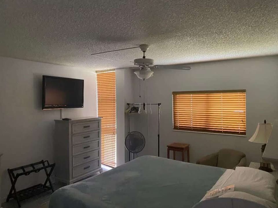 Cozy bedroom with natural light, a king-size bed, and a TV; a peaceful space for relaxation after sun-filled days.