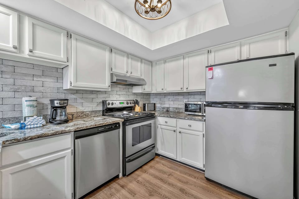 Modern kitchen with granite counters, stainless appliances, and full amenities.