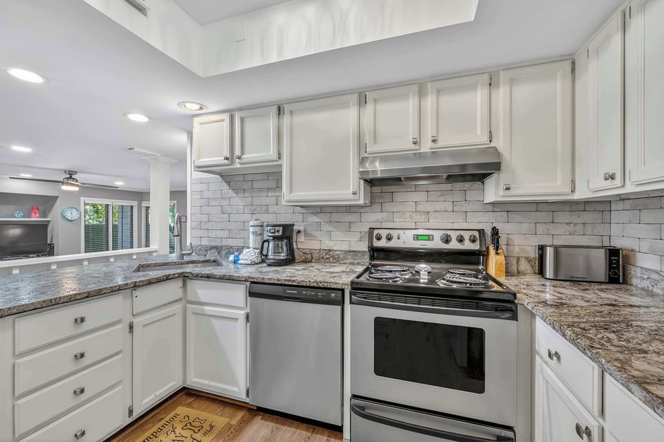 Modern kitchen with granite counters, stainless appliances, and full amenities.