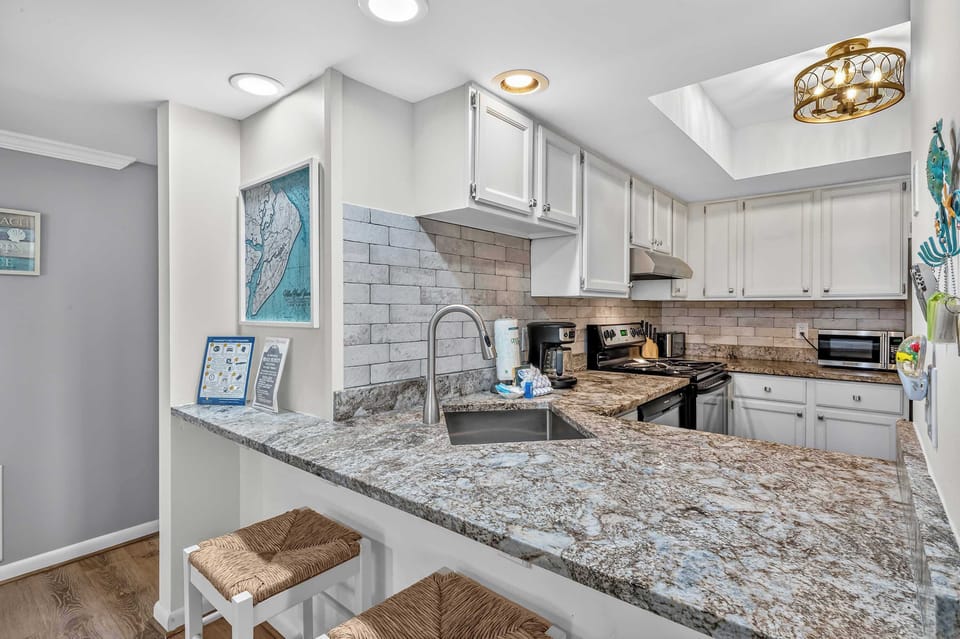 Modern kitchen with granite counters, stainless appliances, and full amenities.