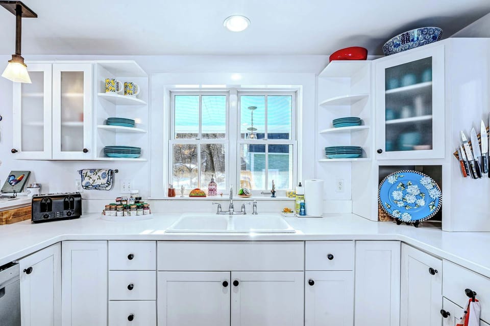 U-shaped kitchen with a farmhouse sink and open shelving