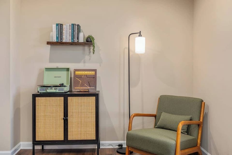 Cozy reading nook with mid-century chair, vinyl player & warm lighting
