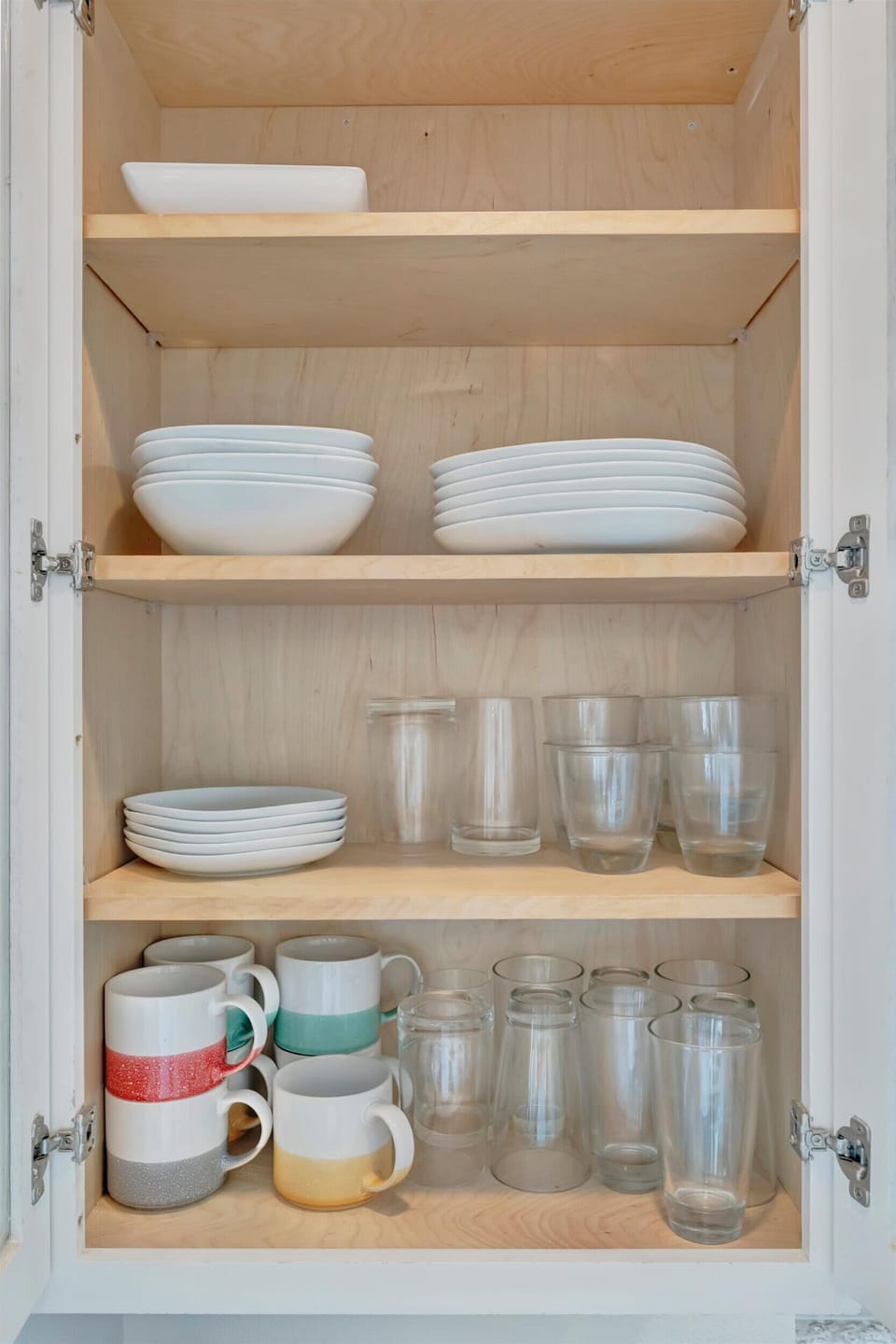 Kitchen cabinet stocked with dishes and glassware