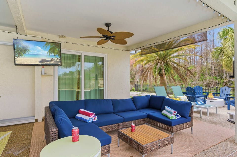 Relaxed living area w/ a large sectional, TV & ceiling fan.
