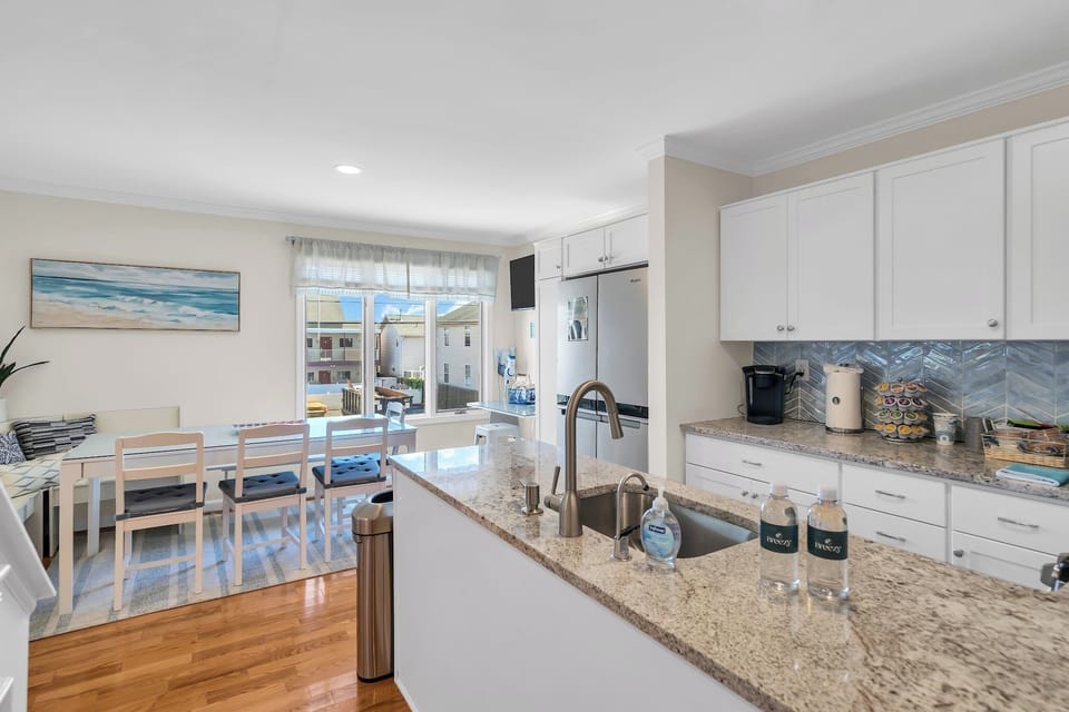 Bright open kitchen and dining space with granite counters and natural light