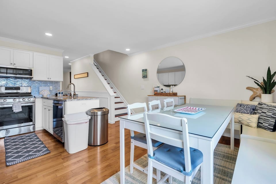 Bright open dining area with full kitchen, seating for four, and cozy touches