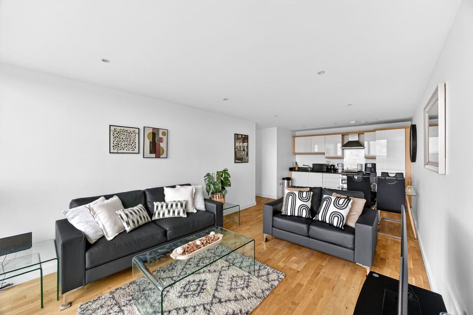 Relax in the cozy living room featuring two comfortable sofas and a smart TV, perfect for unwinding or enjoying your favourite shows.