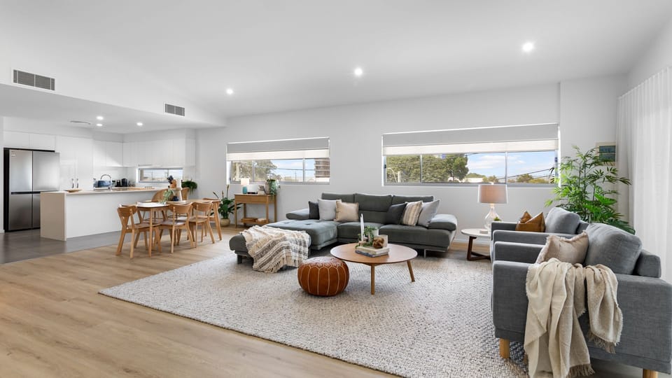 Spacious open-plan living area with comfortable seating and a bright modern kitchen.