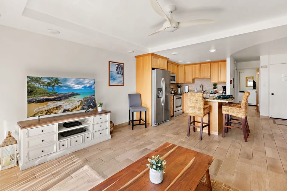Comfortable island-style living space featuring a smart TV and queen sleeper sofa for extra guests.