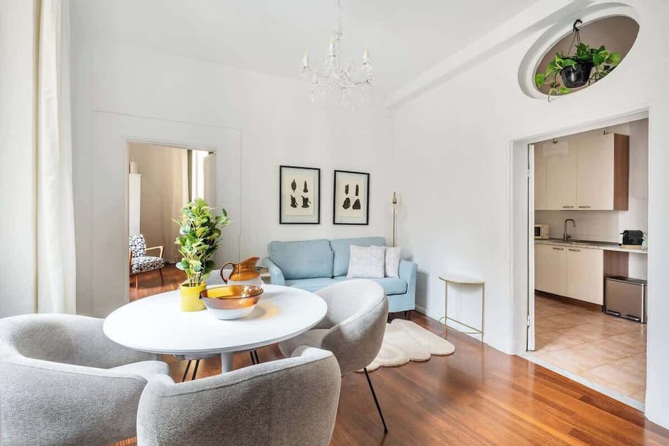 Bright lounge with plush dining, hardwood floors, and separate kitchen