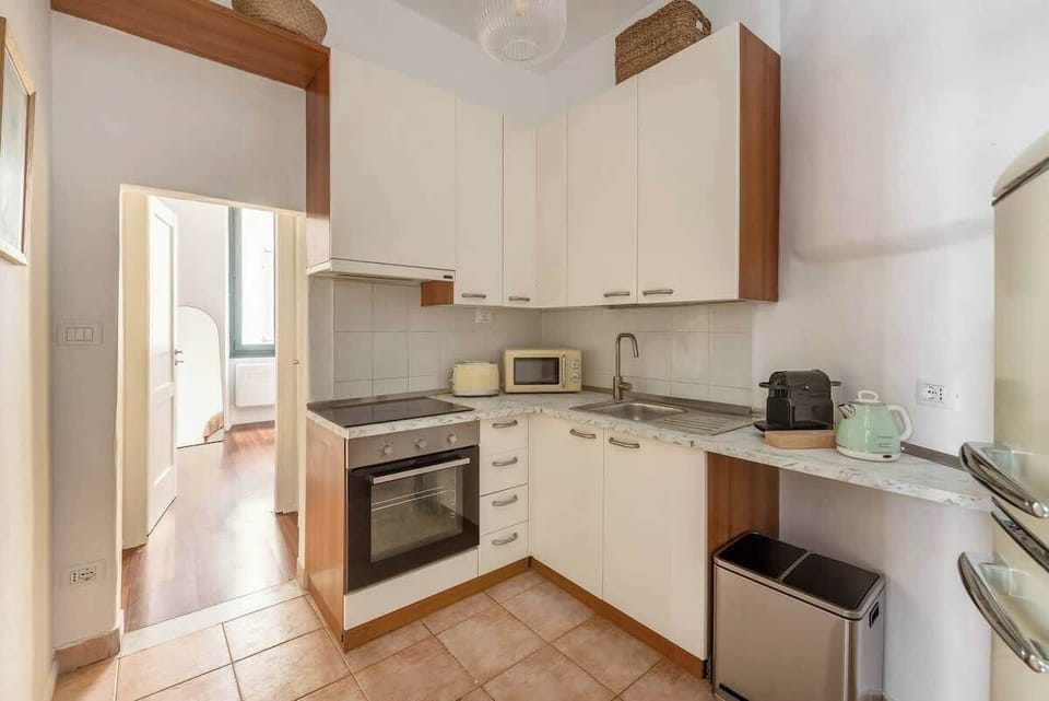 Bright, well-equipped kitchenette with oven, espresso maker, and ample storage.